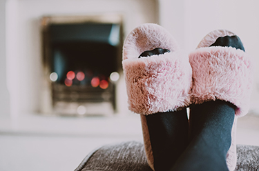 slippered feet in front of fireplace